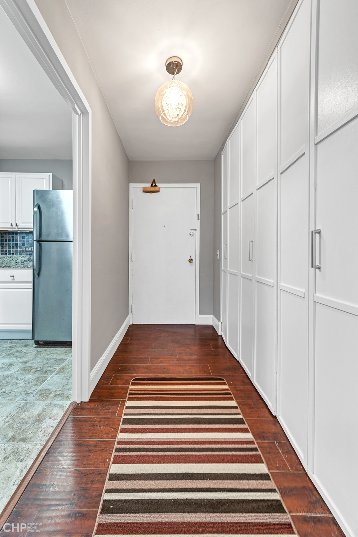 5415 North Sheridan Road, Unit 5409 Chicago, IL 60640 - Photo 13 of 37 a view of a hallway with wooden floor and a chandelier