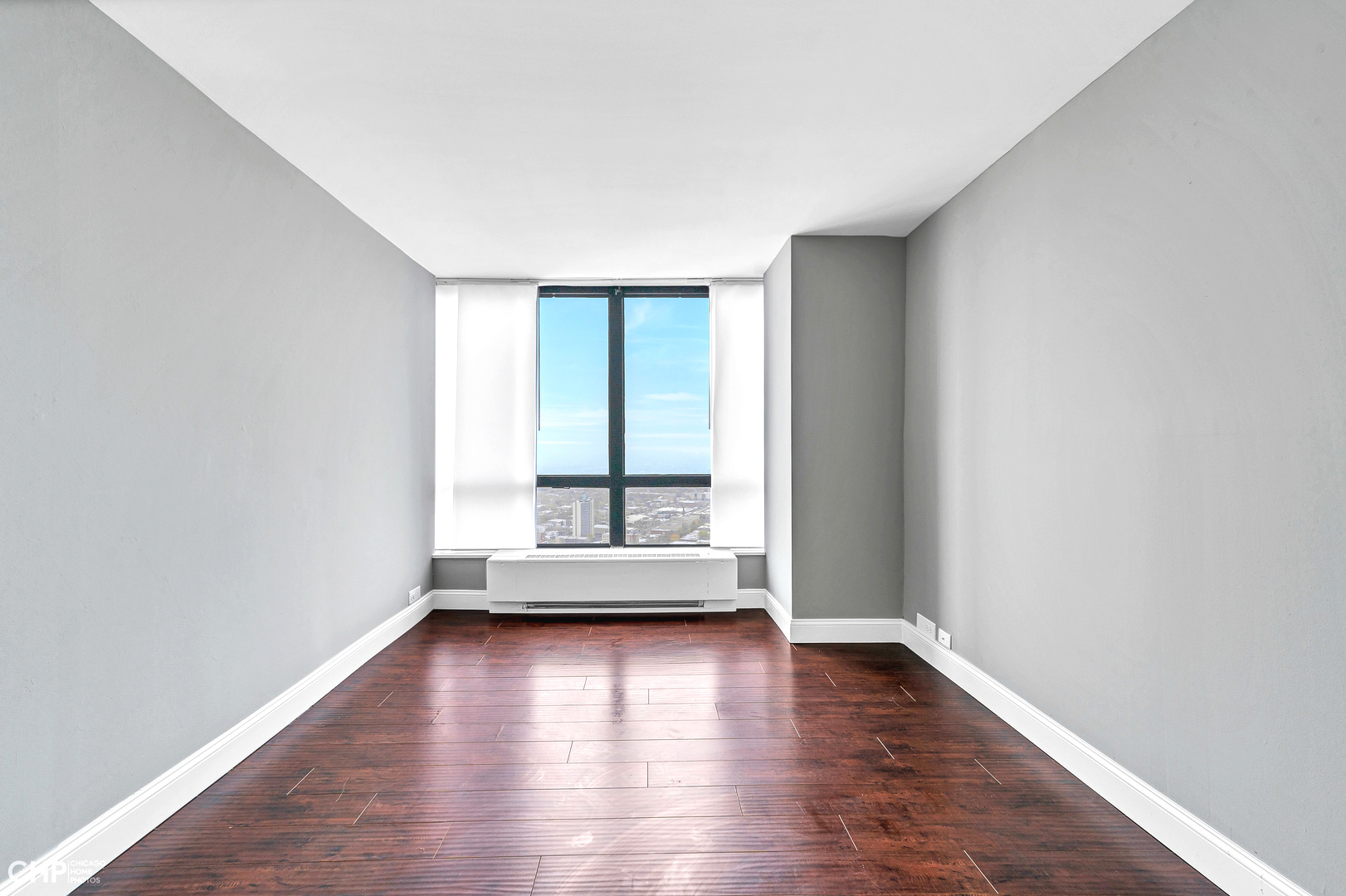 5415 North Sheridan Road, Unit 5409 Chicago, IL 60640 - Photo 14 of 37 an empty room with wooden floor and windows