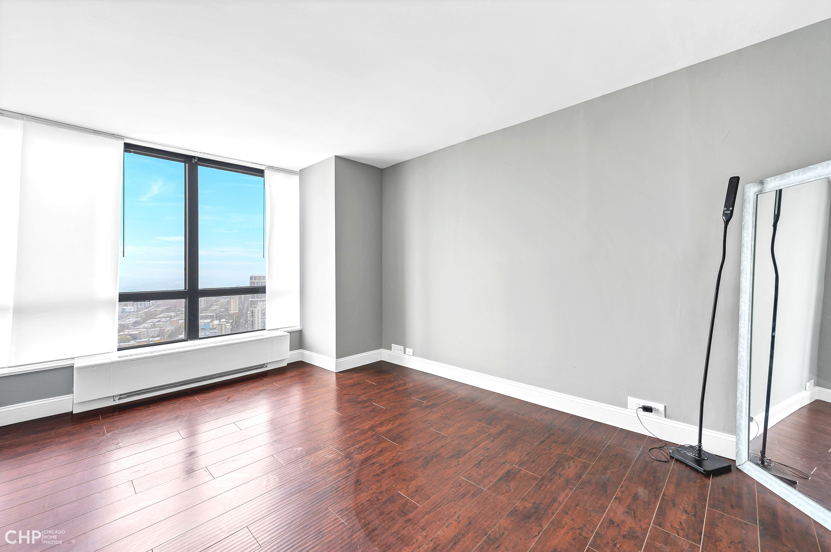 5415 North Sheridan Road, Unit 5409 Chicago, IL 60640 - Photo 16 of 37 an empty room with wooden floor and windows