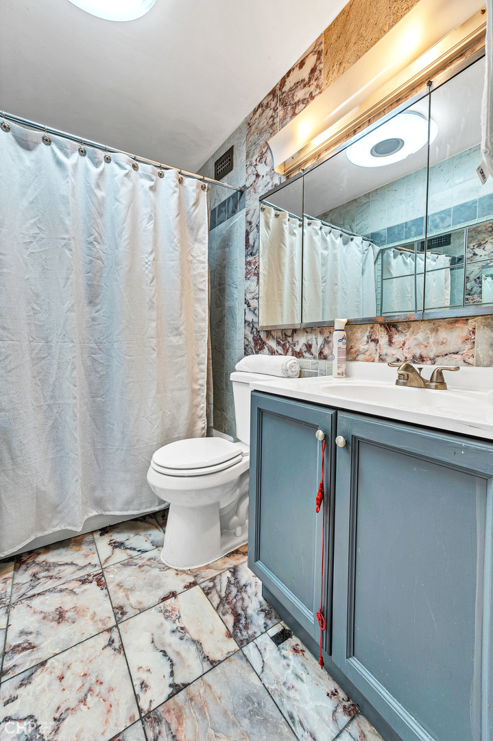 5415 North Sheridan Road, Unit 5409 Chicago, IL 60640 - Photo 17 of 37 a bathroom with a sink toilet and shower