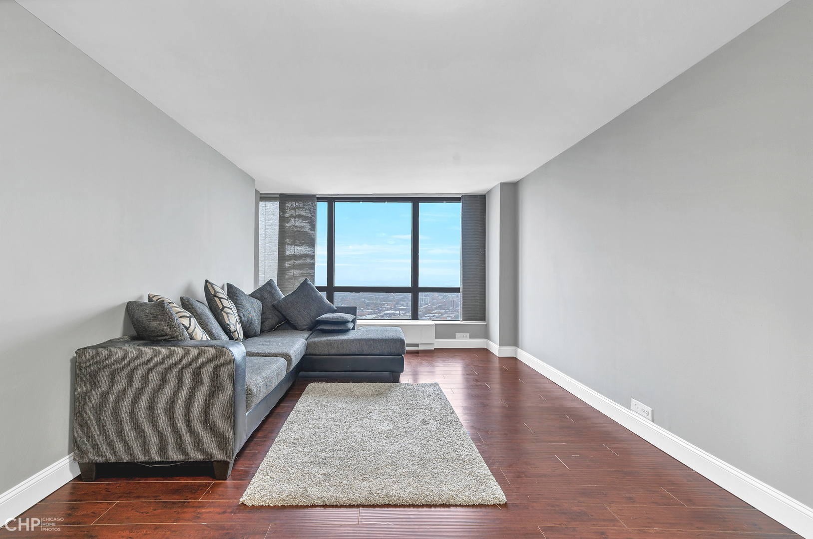5415 North Sheridan Road, Unit 5409 Chicago, IL 60640 - Photo 3 of 37 a living room with furniture wooden floor and a large window