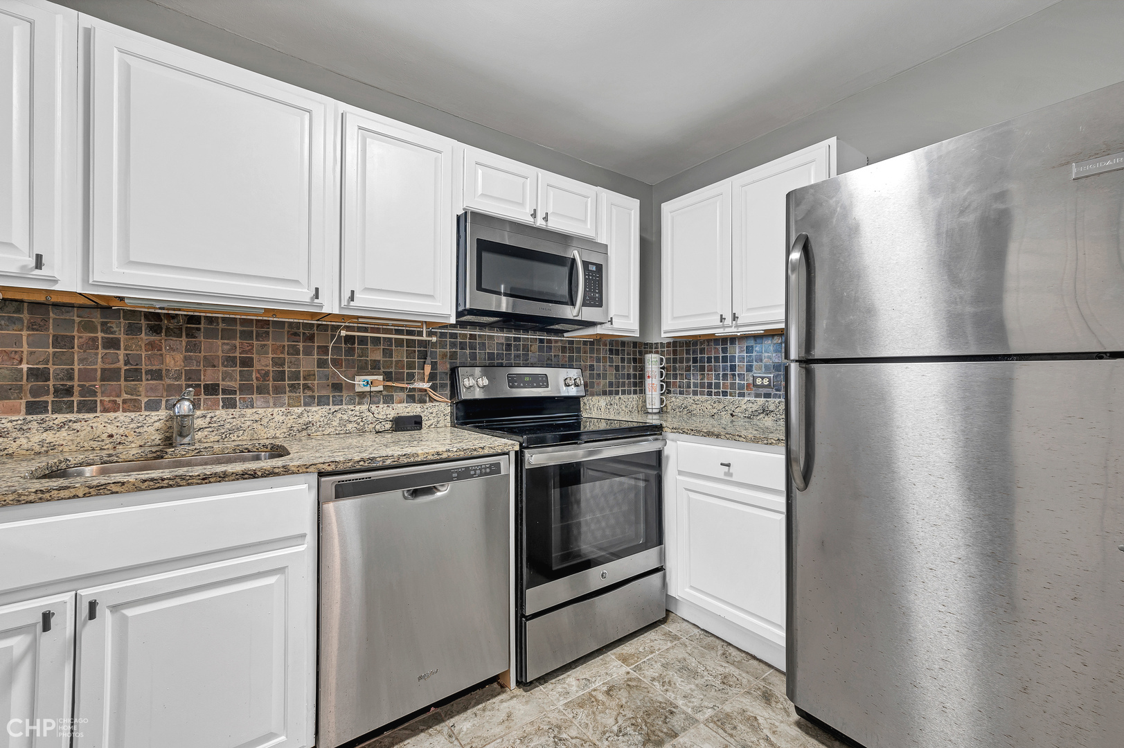 5415 North Sheridan Road, Unit 5409 Chicago, IL 60640 - Photo 10 of 37 a kitchen with stainless steel appliances granite countertop a refrigerator a stove a sink and a microwave