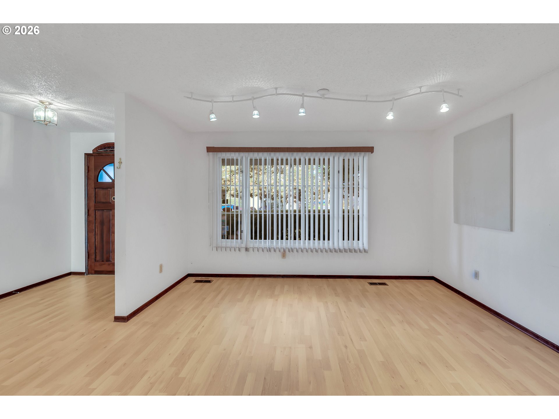 6980 Southwest 130th Avenue Beaverton, OR 97008 - Photo 5 of 38 a view of an empty room with wooden floor and a window