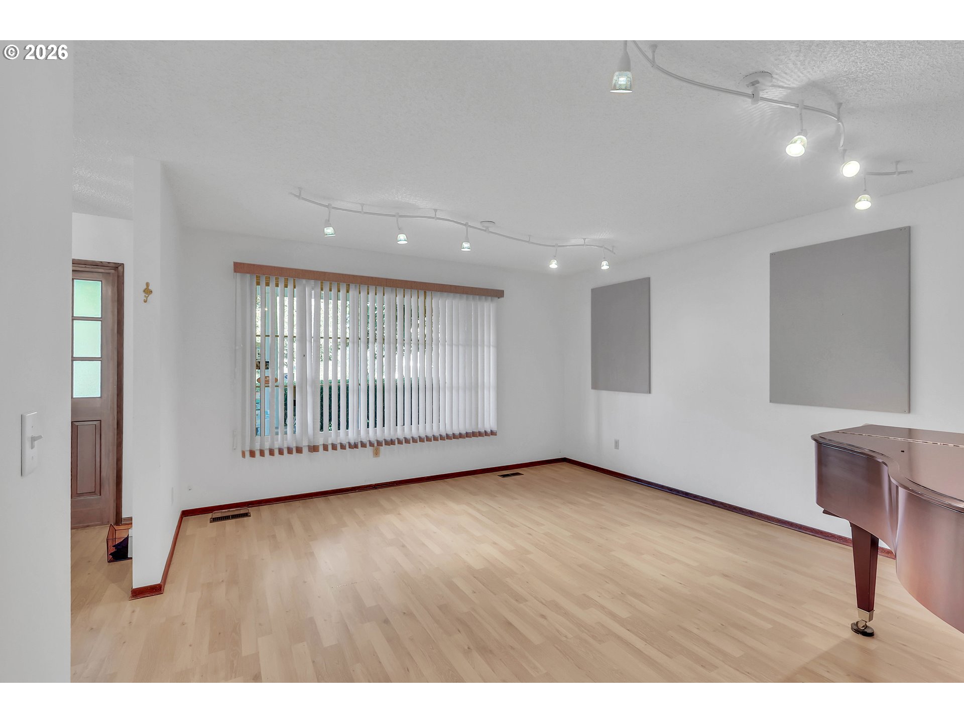 6980 Southwest 130th Avenue Beaverton, OR 97008 - Photo 7 of 38 a view of an empty room with wooden floor and a window