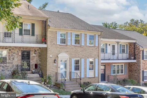 a front view of a house with cars parked