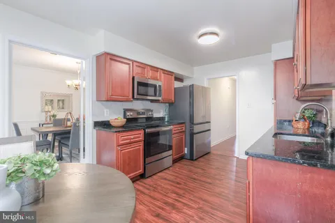 a kitchen with stainless steel appliances granite countertop a refrigerator a stove top oven a sink and dishwasher