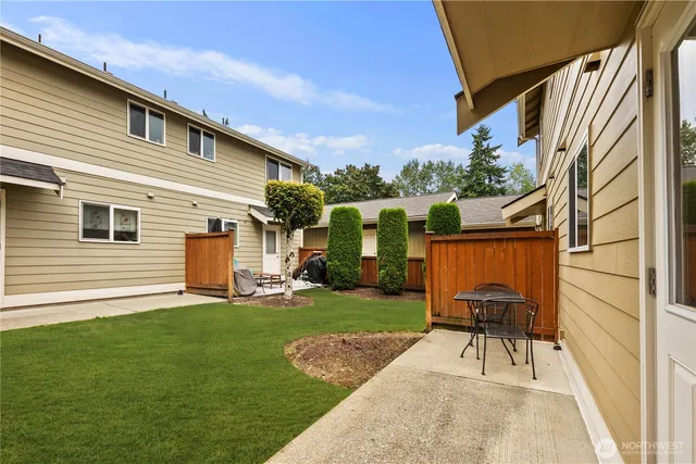 a backyard of a house with table and chairs