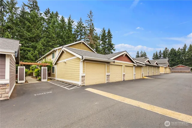 a view of a house with a yard and large tree
