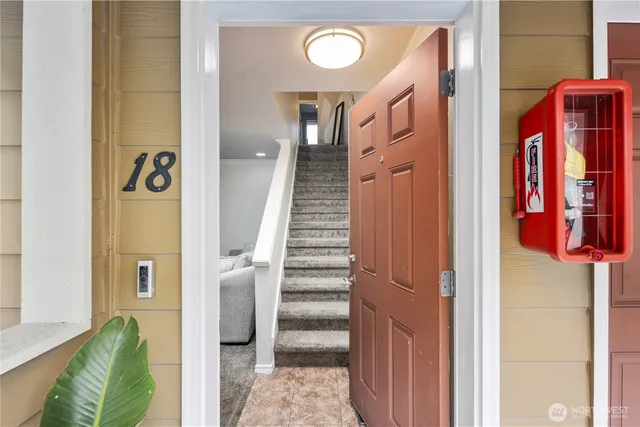 a view of a hallway with entryway and stairs