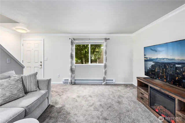 a living room with furniture a flat screen tv and a window