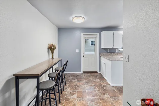 a kitchen with granite countertop a table and chairs in it
