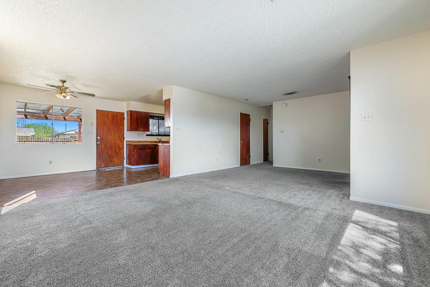 180 Monroe Street Coalinga, CA 93210 - Photo 11 of 25 an empty room with furniture and a kitchen