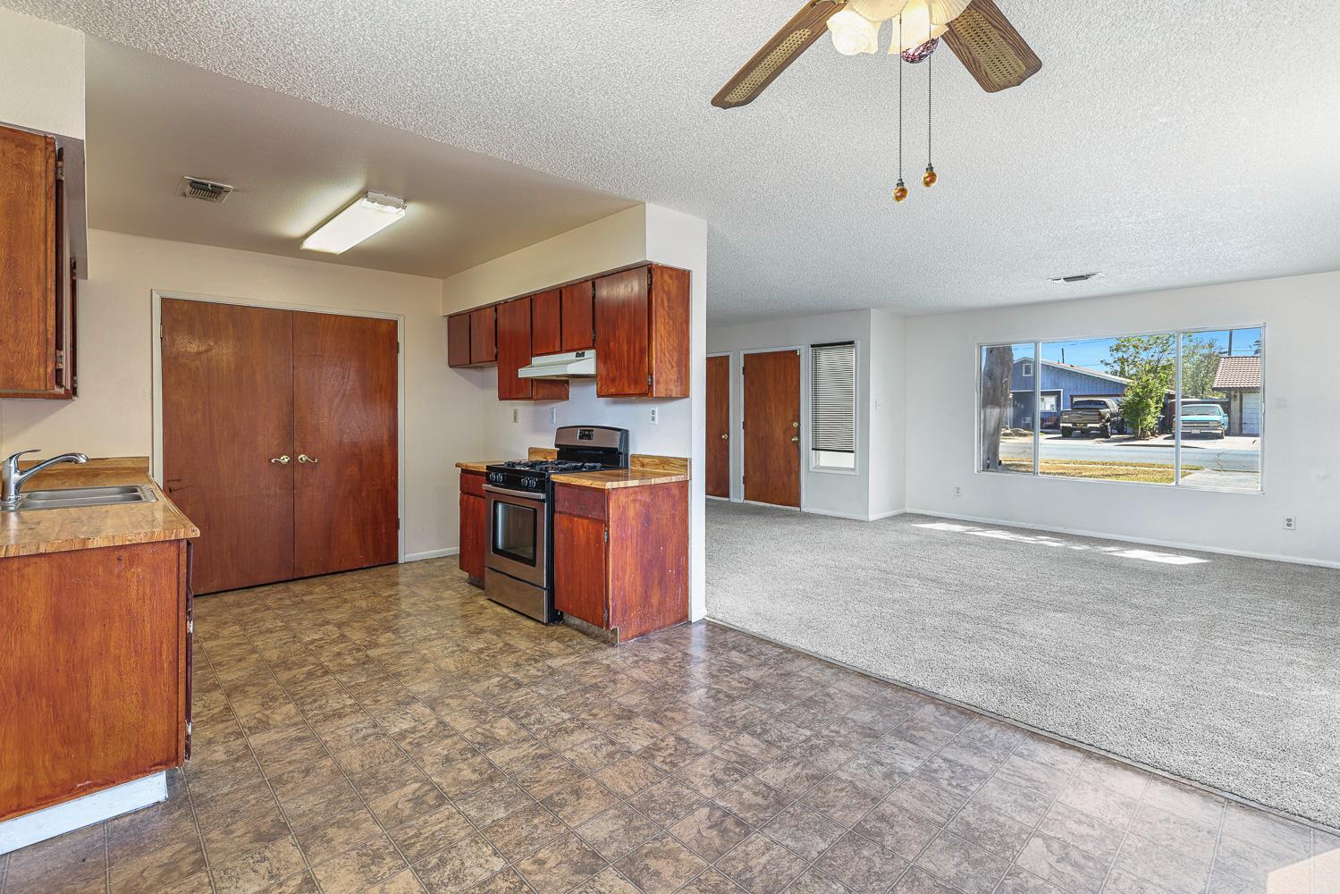 180 Monroe Street Coalinga, CA 93210 - Photo 12 of 25 a kitchen with stainless steel appliances kitchen island granite countertop a refrigerator and a stove top oven