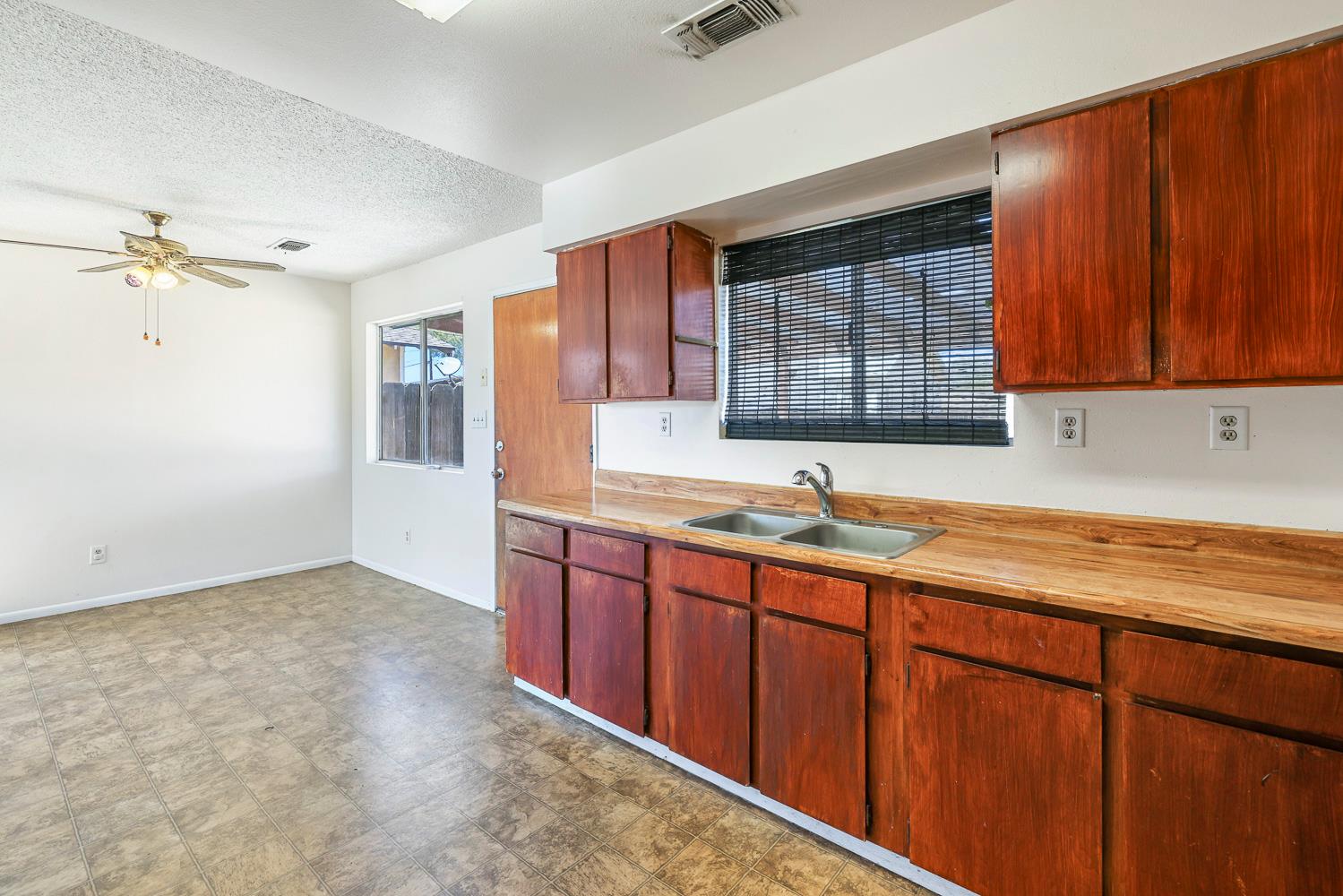 180 Monroe Street Coalinga, CA 93210 - Photo 13 of 25 a kitchen with stainless steel appliances granite countertop wooden cabinets a sink and a window