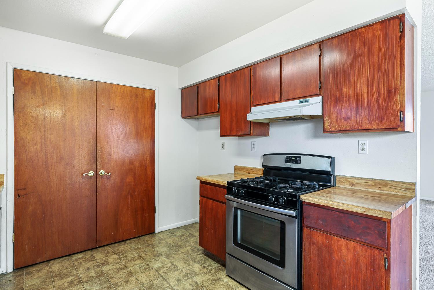 180 Monroe Street Coalinga, CA 93210 - Photo 14 of 25 a kitchen with granite countertop cabinets stainless steel appliances and wooden cabinets