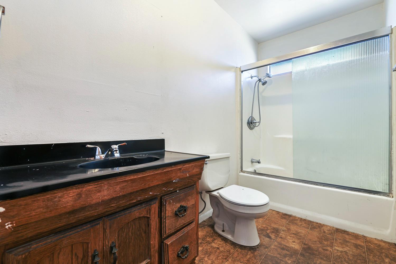 180 Monroe Street Coalinga, CA 93210 - Photo 21 of 25 a bathroom with a toilet a sink and shower