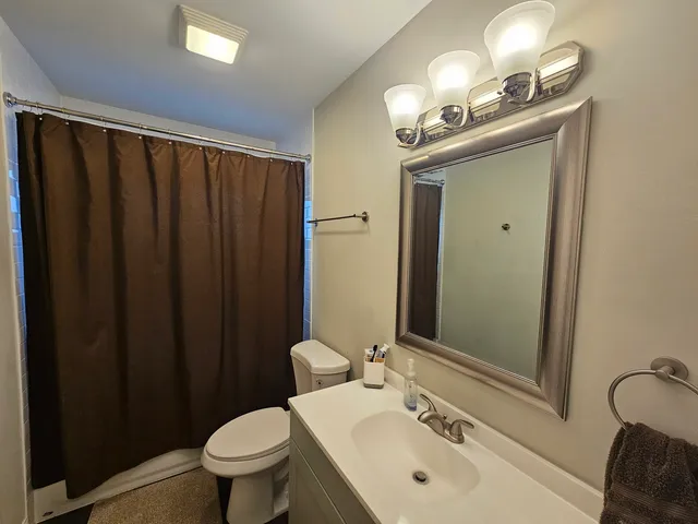 a bathroom with a sink vanity mirror and toilet