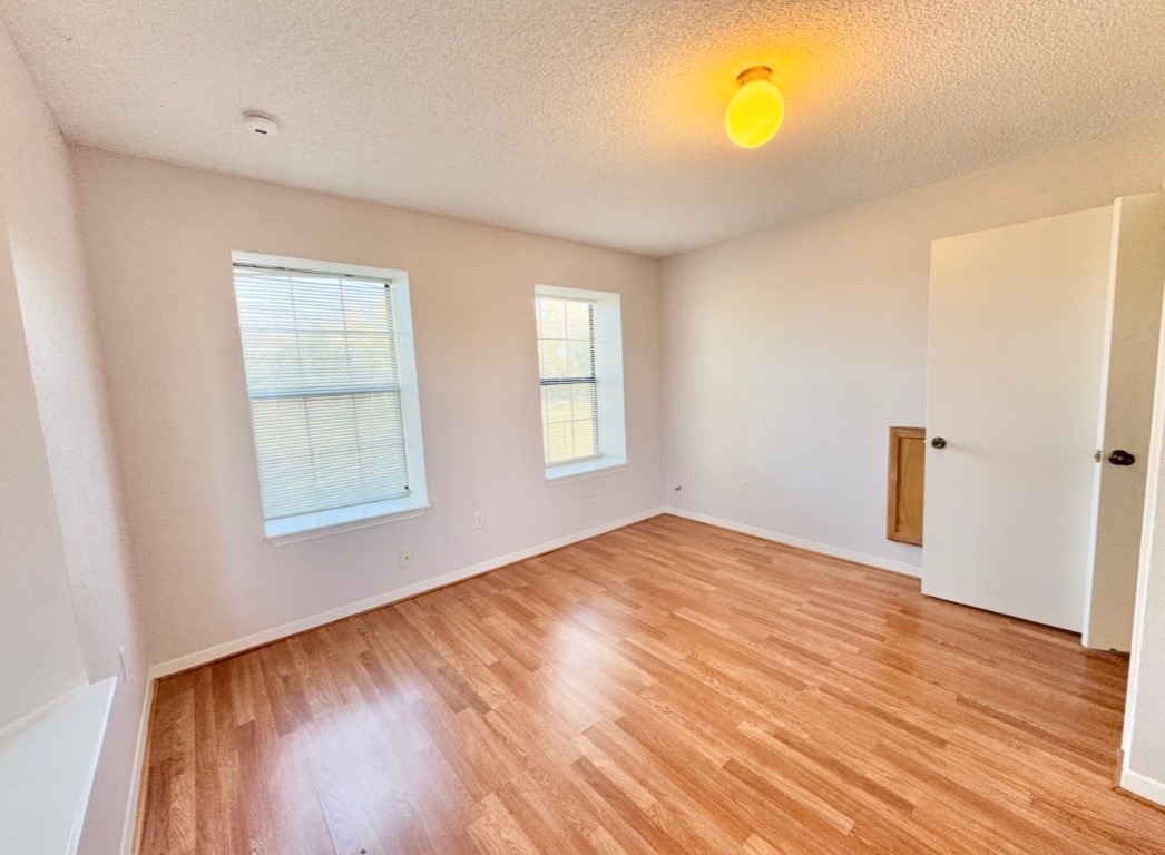 233 Farm To Market 696 Elgin, TX 78621 - Photo 13 of 28 a view of empty room with wooden floor and fan
