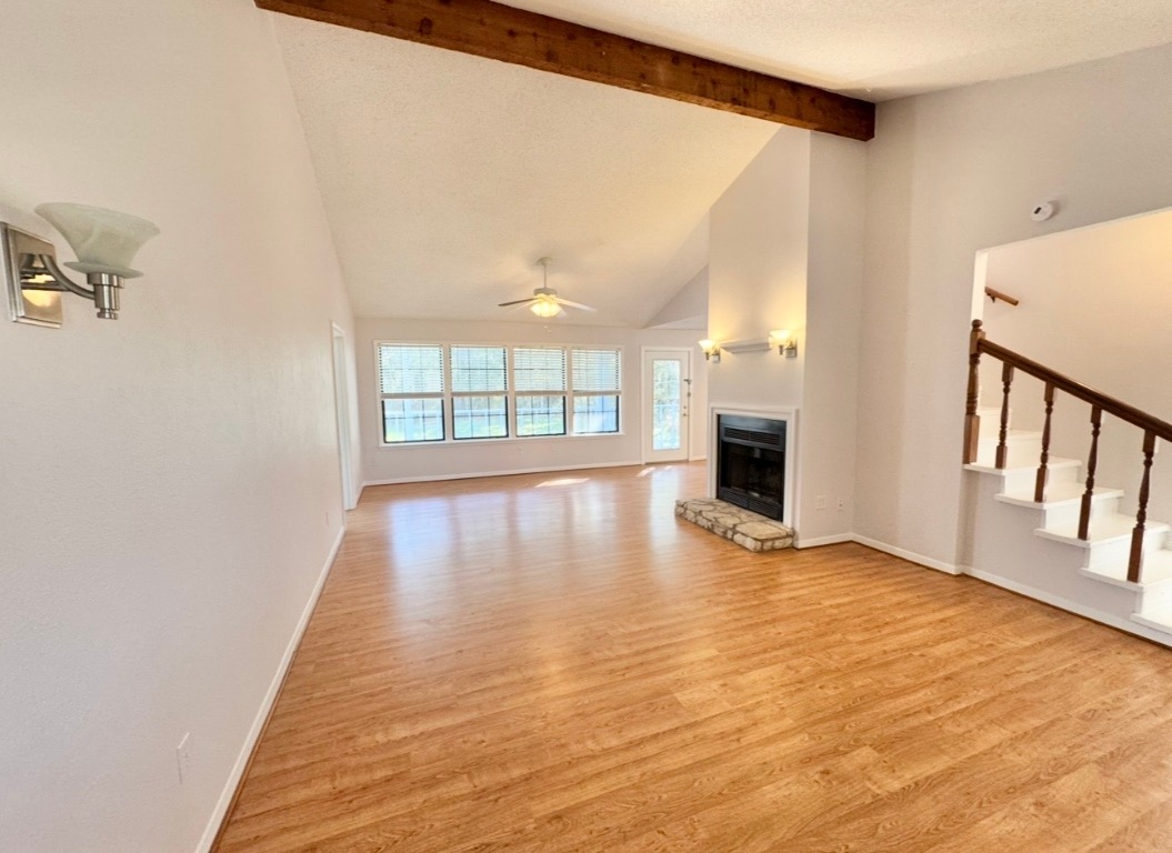 233 Farm To Market 696 Elgin, TX 78621 - Photo 4 of 28 wooden floor in an empty room with a fireplace and a window