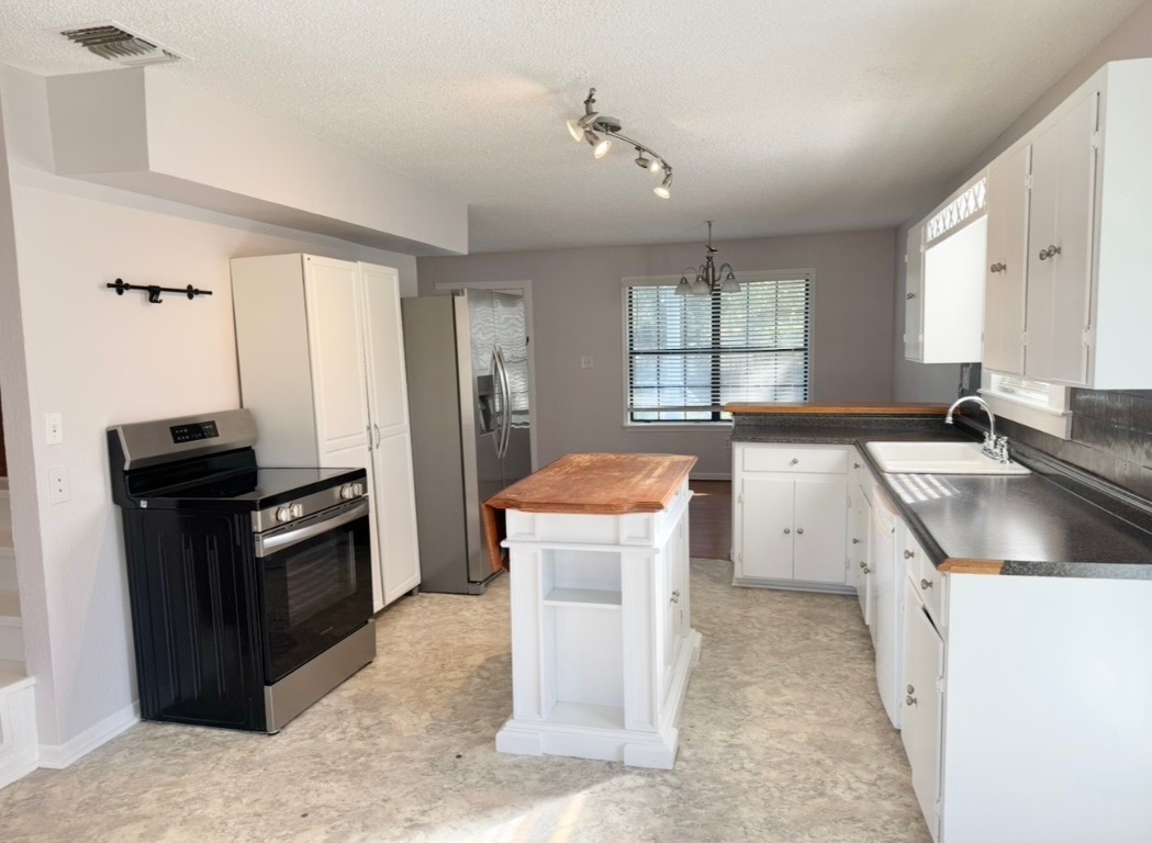 233 Farm To Market 696 Elgin, TX 78621 - Photo 6 of 28 a kitchen with a stove sink and a refrigerator