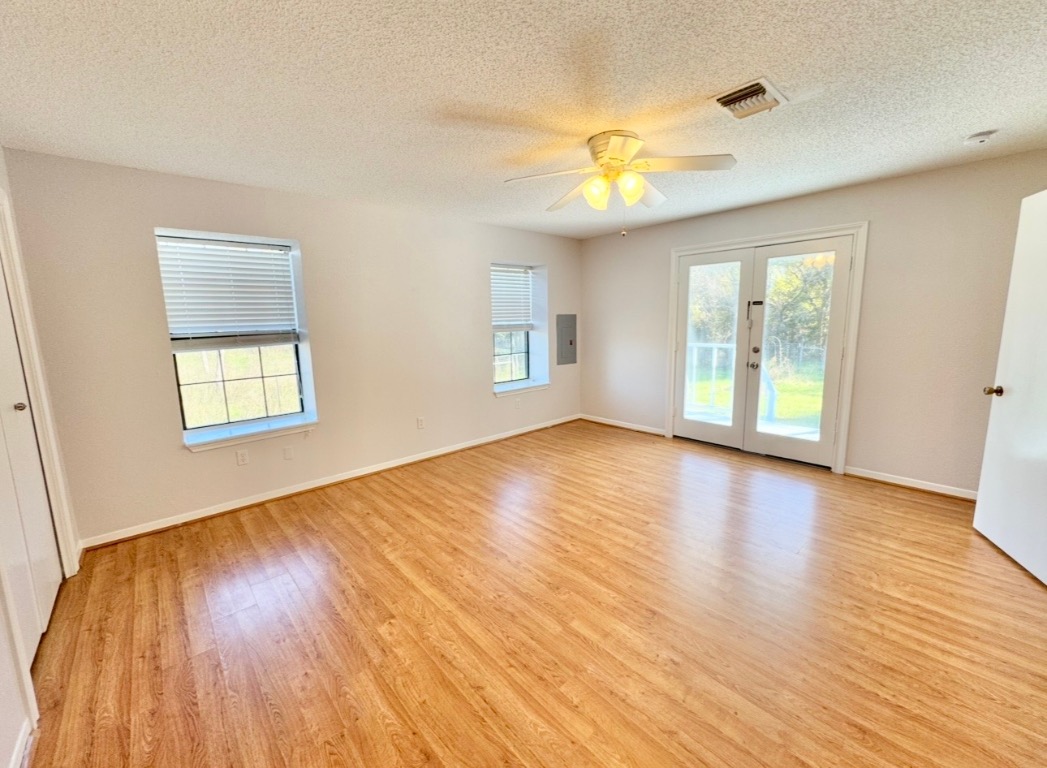 233 Farm To Market 696 Elgin, TX 78621 - Photo 9 of 28 an empty room with wooden floor and windows