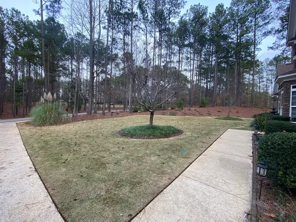 a view of a room with wooden floor chandelier and windows