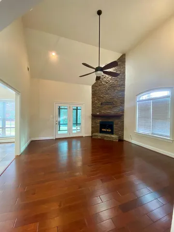 an empty room with a ceiling fan and window