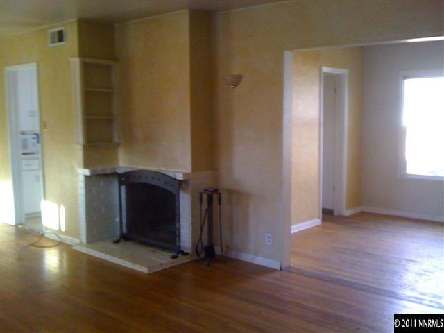 950 Meadow Street Reno, NV 89509 - Photo 3 of 9 an empty room with wooden floor and windows