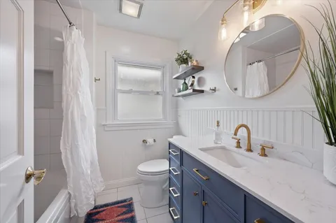 a bathroom with a double vanity sink mirror and toilet