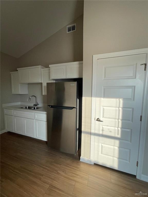 509 Sparrow Road, Unit 3 Weslaco, TX 78596 - Photo 9 of 19 a kitchen with a refrigerator and white cabinets