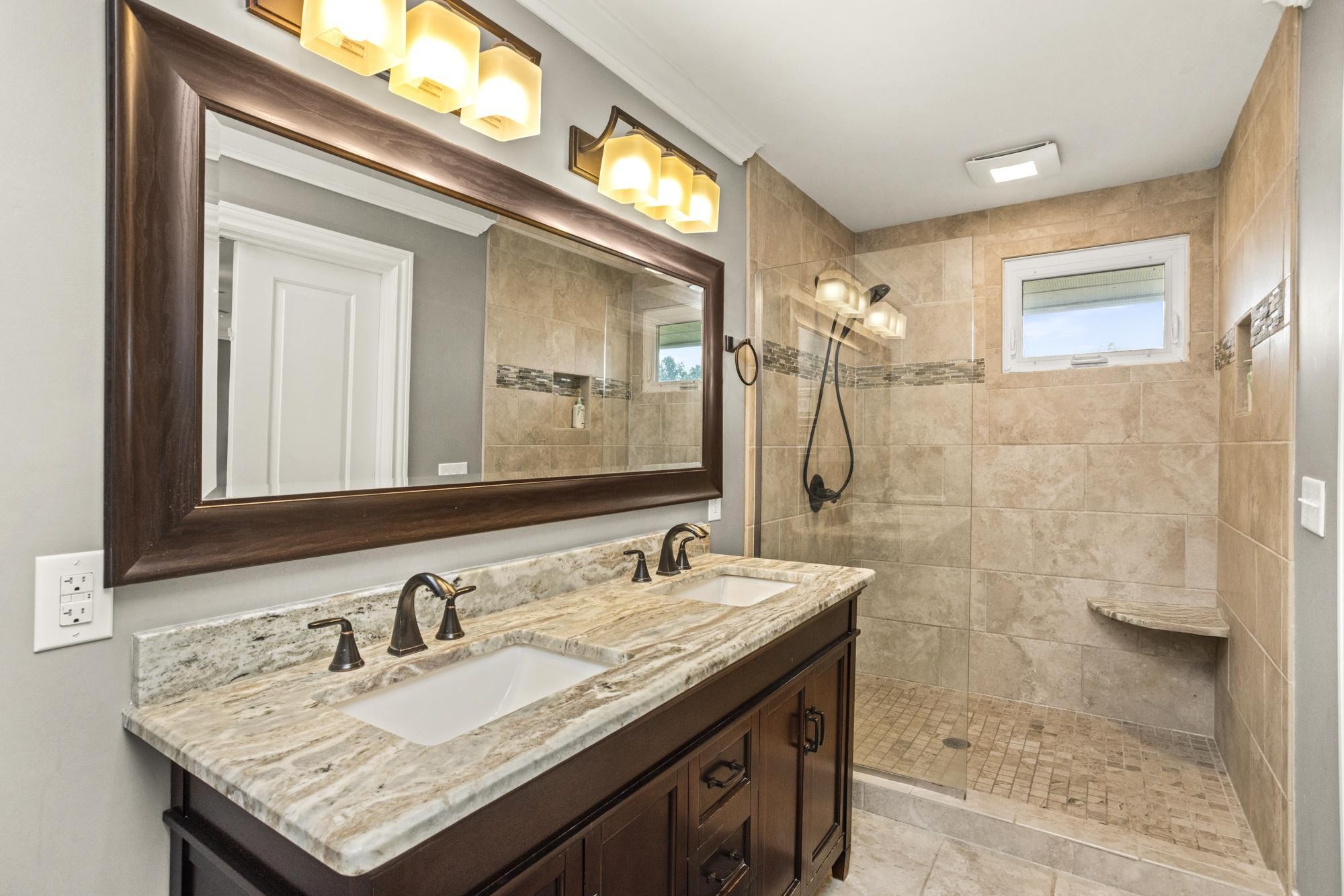 8733 Haselton Road Nashville, TN 37221 - Photo 16 of 29 a bathroom with a granite countertop sink a large mirror and a shower
