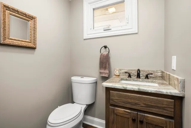 a bathroom with a toilet sink and mirror