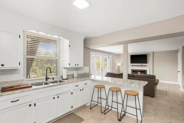 a kitchen with stainless steel appliances granite countertop a stove a sink dishwasher and a microwave oven with white cabinets