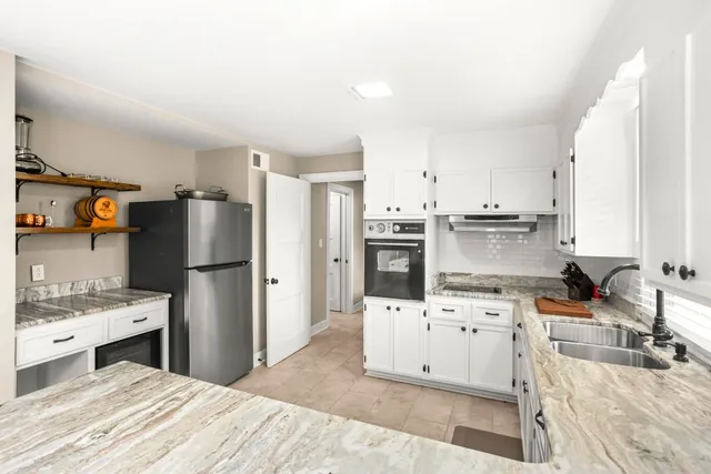 a kitchen with white cabinets and stainless steel appliances