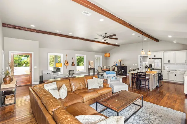 a living room with furniture kitchen view and a large window