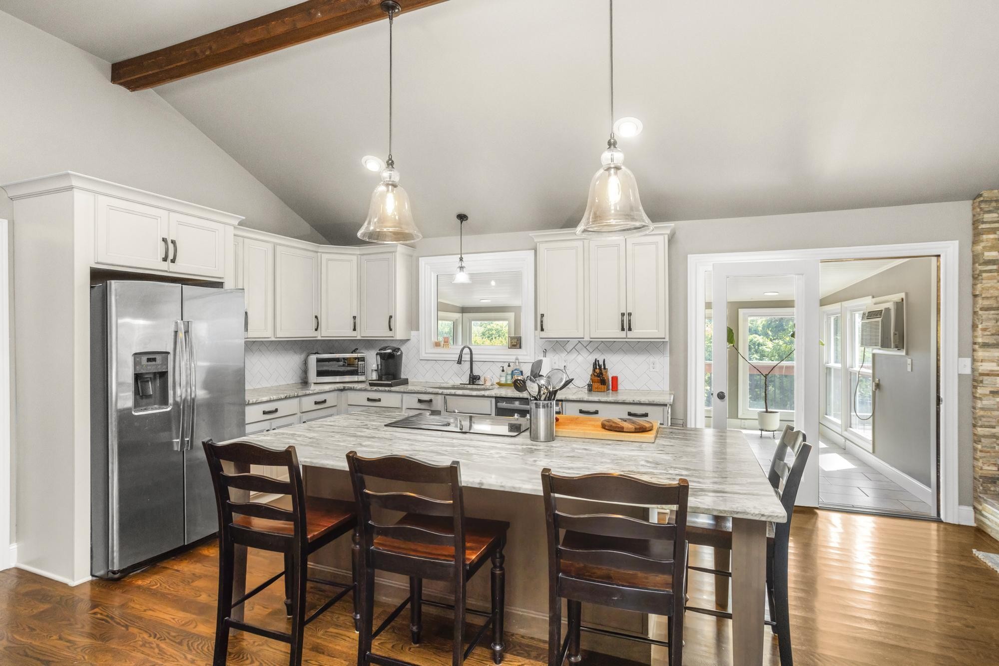 8733 Haselton Road Nashville, TN 37221 - Photo 9 of 29 a kitchen with stainless steel appliances a dining table chairs refrigerator and microwave