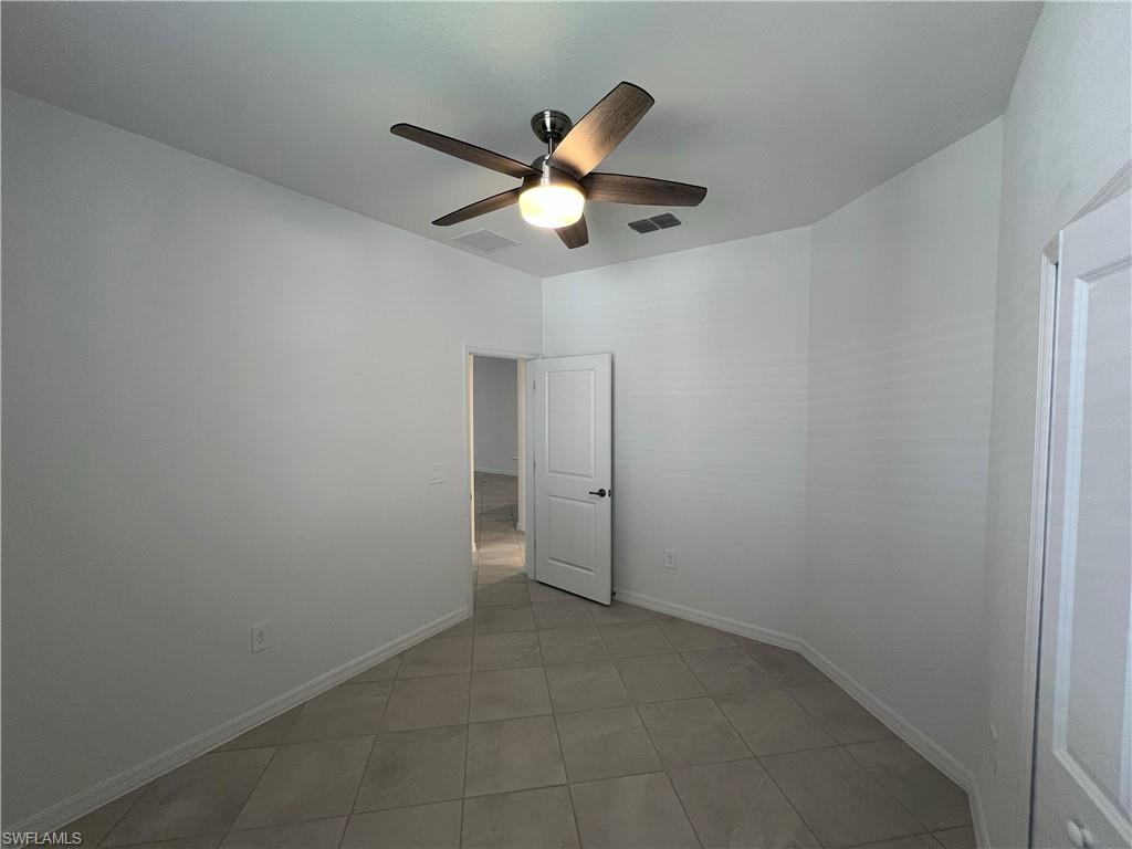 2320 Dragonfruit Way Naples, FL 34120 - Photo 12 of 33 Unfurnished room featuring ceiling fan, baseboards, visible vents, and light tile patterned floors