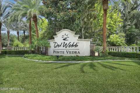 a living room with patio furniture and a floor to ceiling window