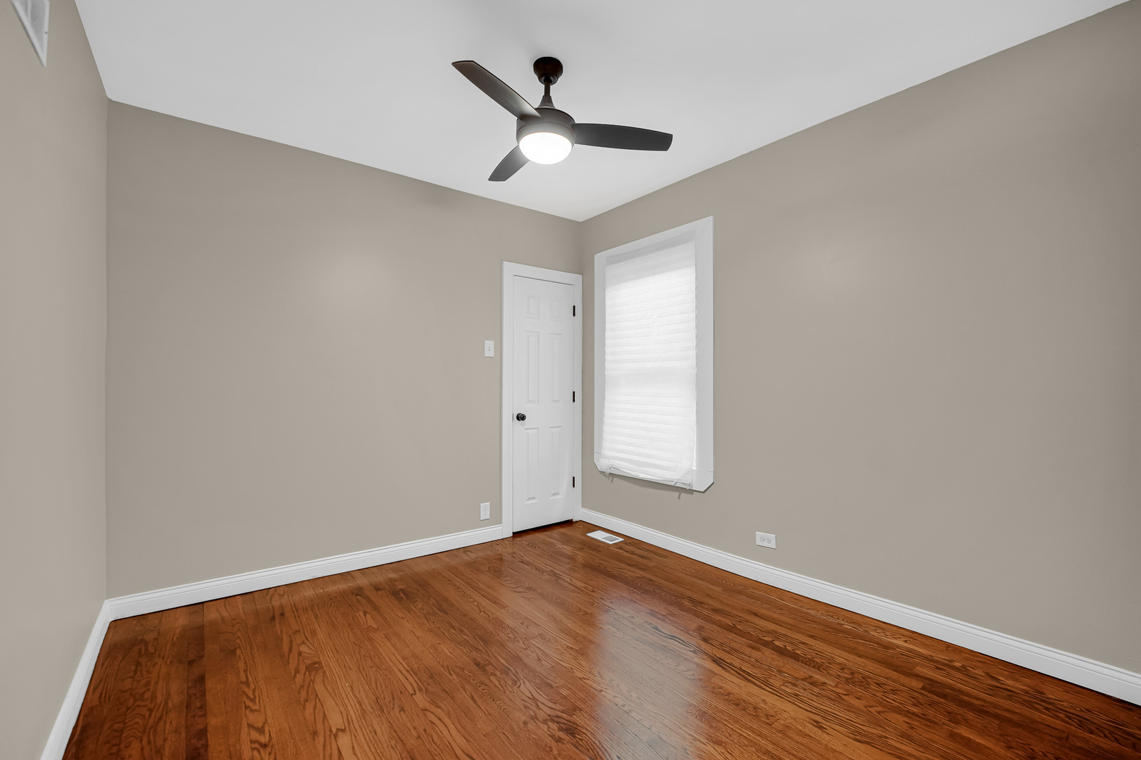 9327 South Elizabeth Street Chicago, IL 60620 - Photo 9 of 18 an empty room with wooden floor and ceiling fan