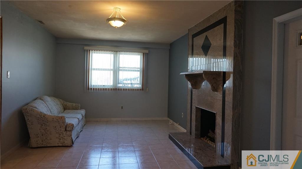 8 Plumstead Road Sewell, NJ 08080 - Photo 11 of 25 a view of an empty room with a fireplace and a window