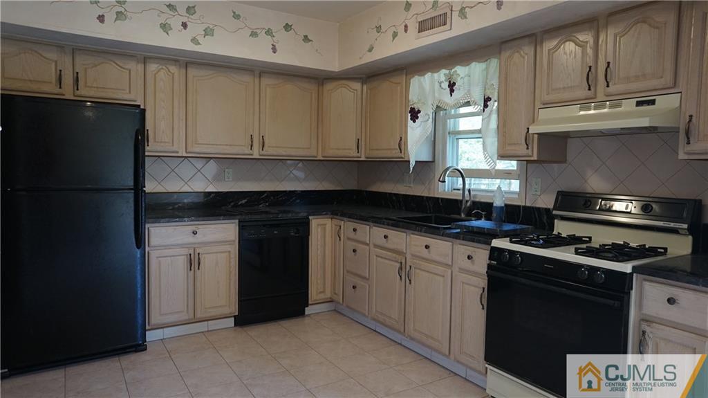 8 Plumstead Road Sewell, NJ 08080 - Photo 5 of 25 a kitchen with granite countertop a refrigerator stove and white cabinets