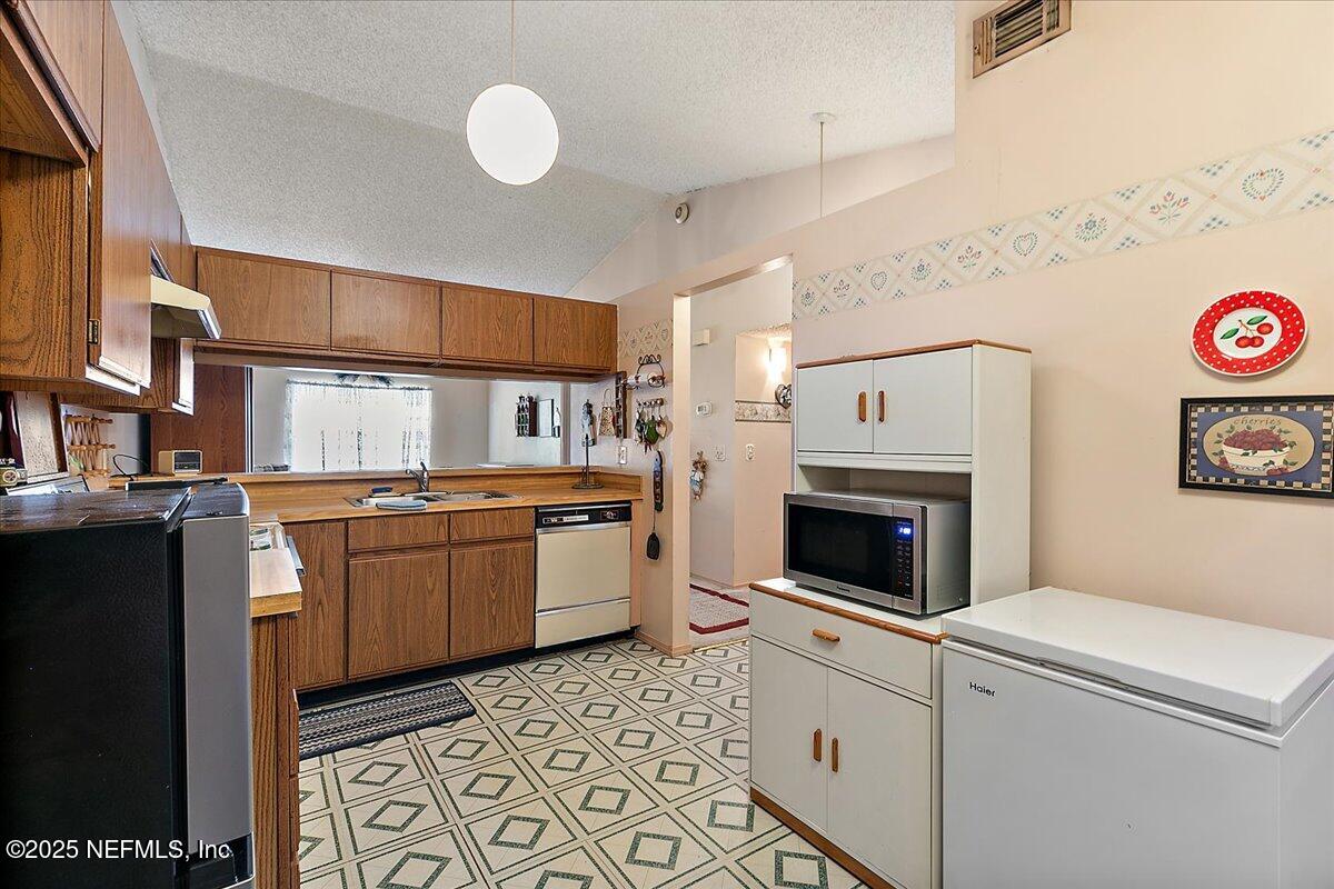 3608 Chappi Way Jacksonville, FL 32223 - Photo 5 of 14 a kitchen with a refrigerator and a stove top oven