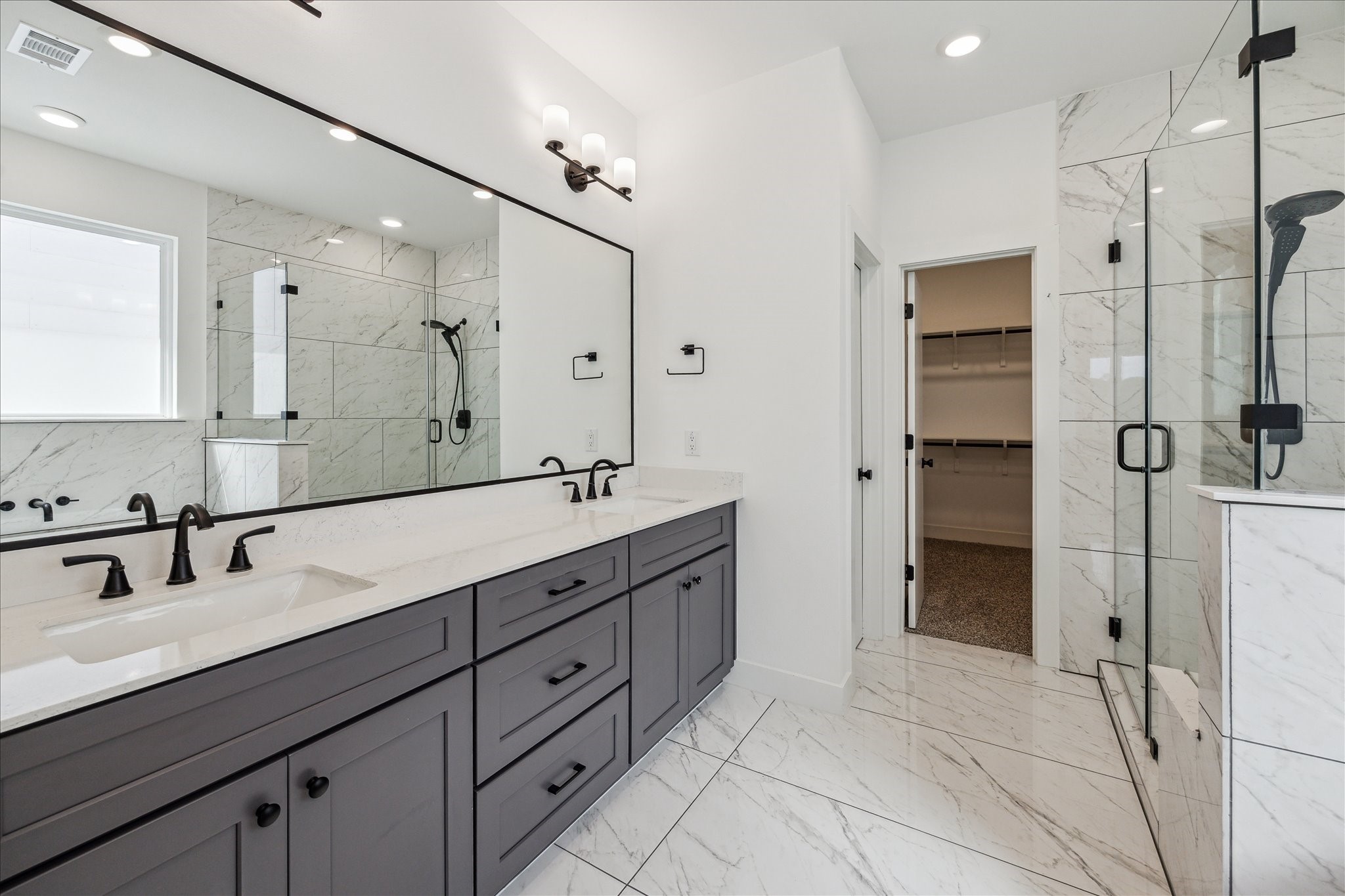 4854 Brinkman Street Houston, TX 77018 - Photo 13 of 30 Luxurious primary bath with dual vanities, quartz counters, large mirror, modern light fixtures and a glass-enclosed shower with modern finishes.