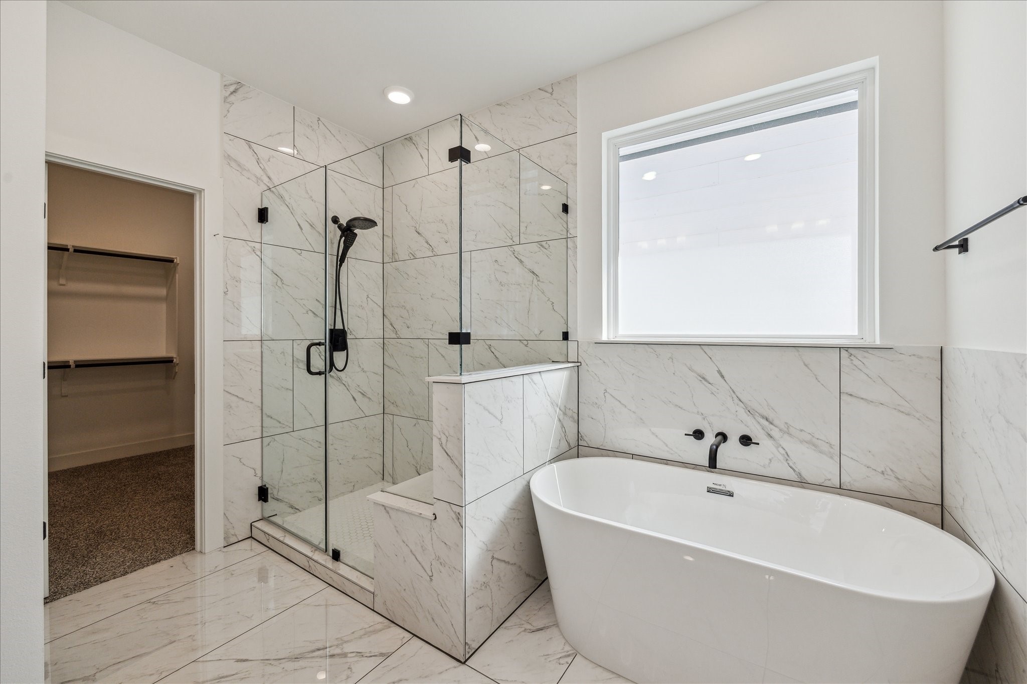 4854 Brinkman Street Houston, TX 77018 - Photo 14 of 30 Spa-like primary bath features a large freestanding soaking tub, frameless glass shower, and beautiful tile throughout. A large window provides natural light in and brightens the space.