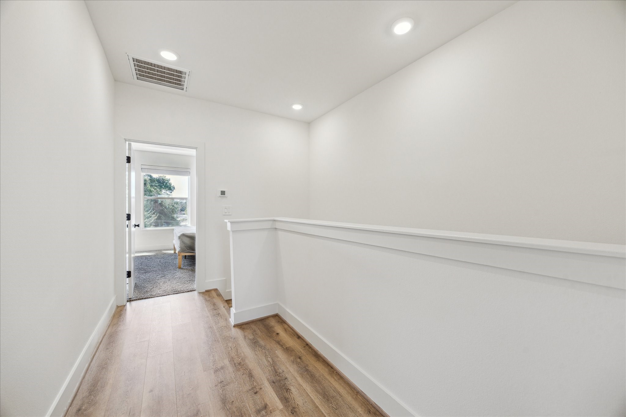 4854 Brinkman Street Houston, TX 77018 - Photo 17 of 30 Bright landing with modern finishes and clean sightlines leads from the primary suite to a secondary bedroom.