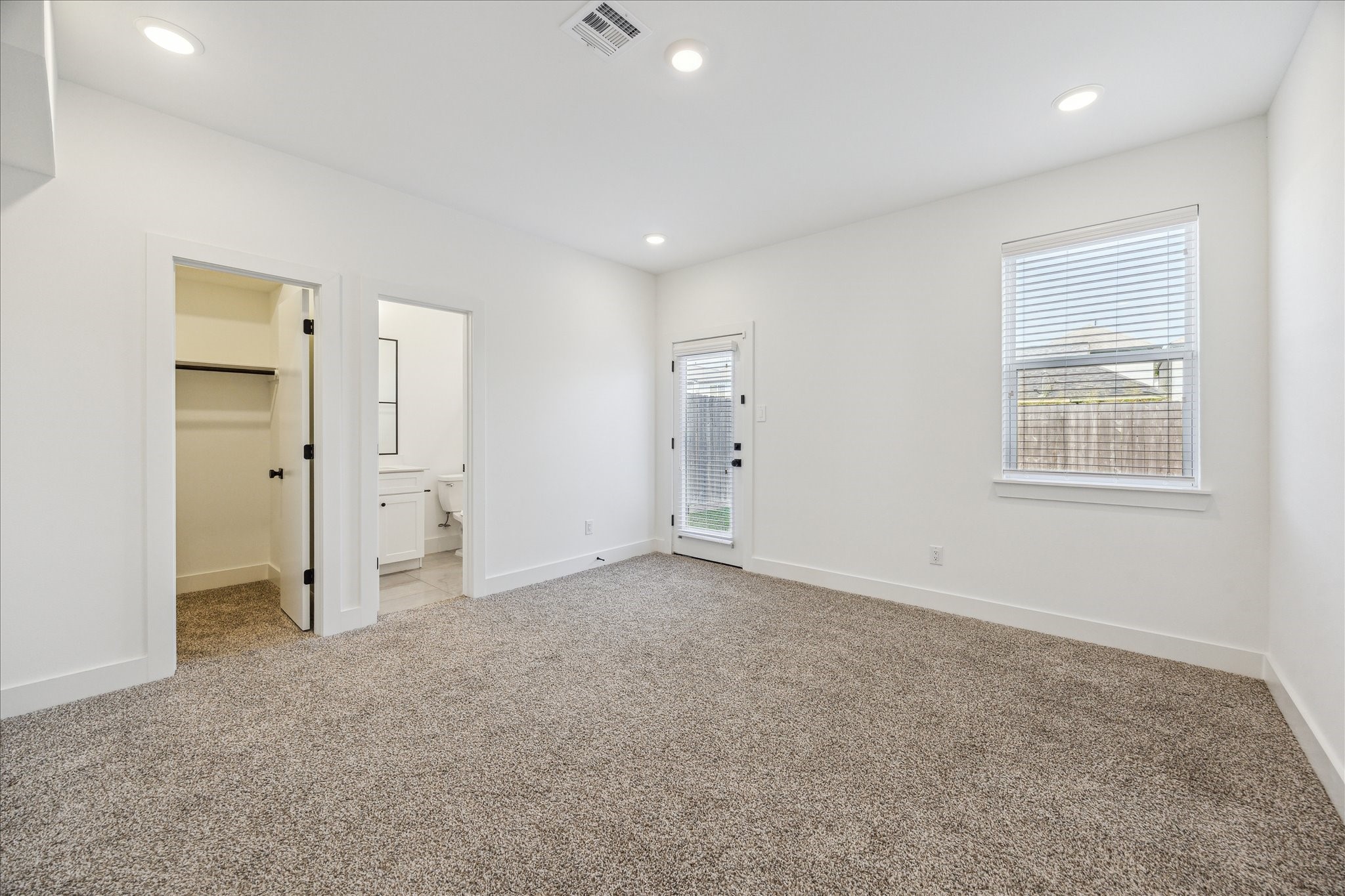 4854 Brinkman Street Houston, TX 77018 - Photo 19 of 30 his view highlights the first-floor bedroom with sightlines into the ensuite bath and walk-in closet. The glass door along with the large window fill the room in natural light.