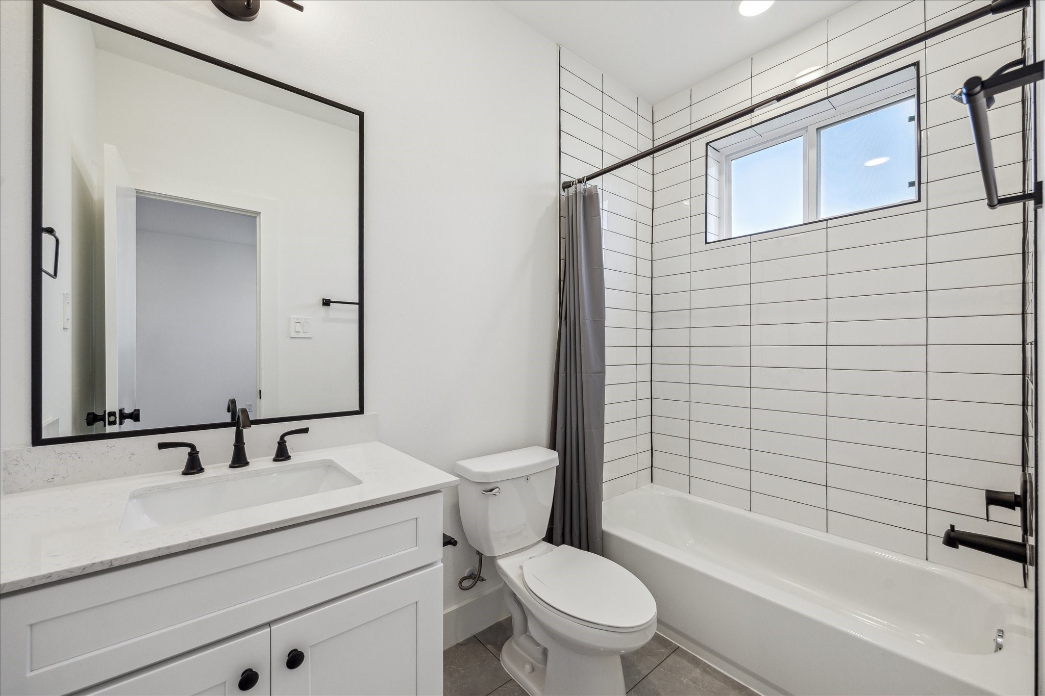 4854 Brinkman Street Houston, TX 77018 - Photo 22 of 30 The secondary bedrooms each feature stylish baths with sleek tile, modern fixtures, and a bright, clean design.
