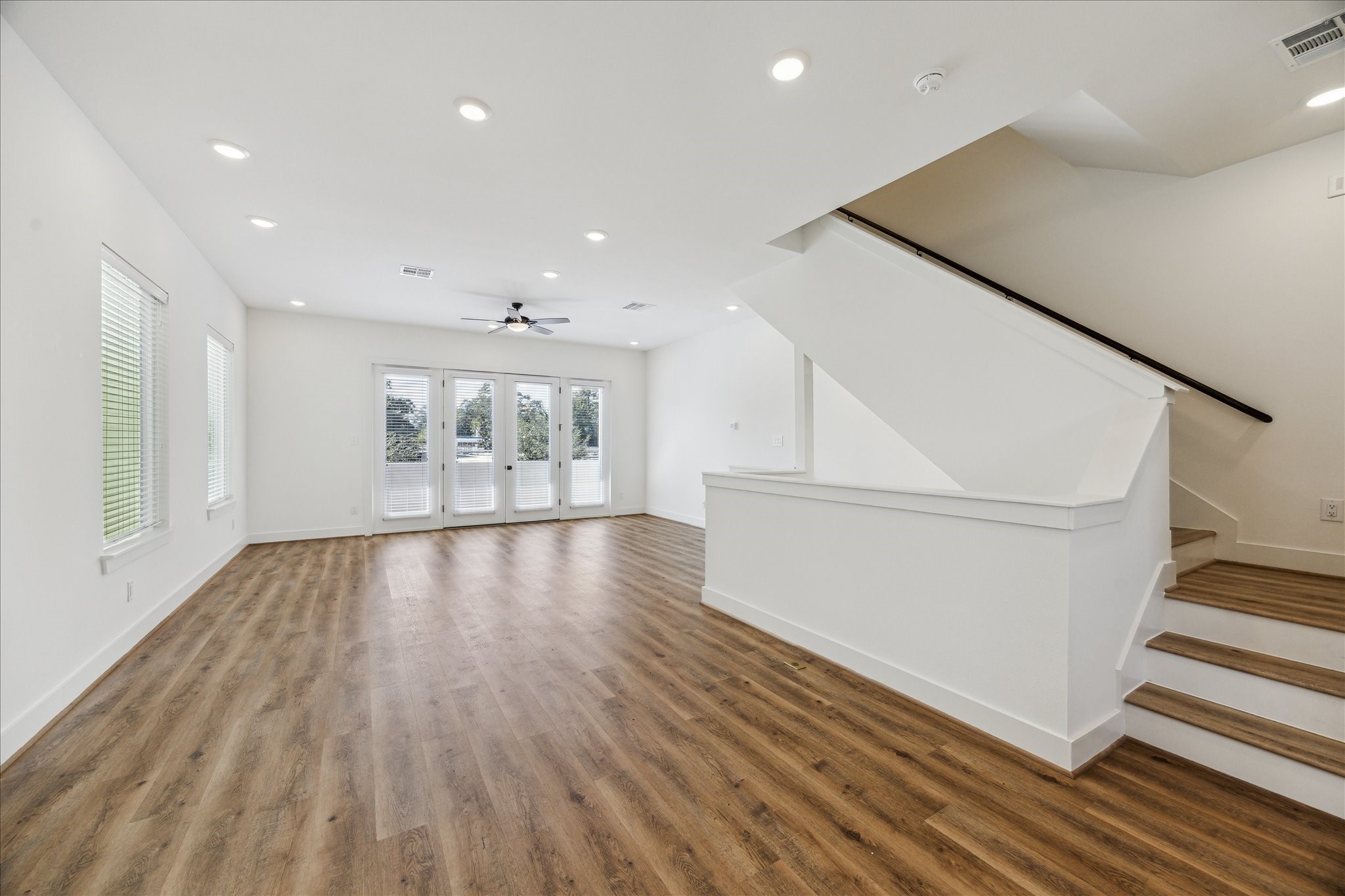 4854 Brinkman Street Houston, TX 77018 - Photo 3 of 30 Spacious second-floor living with sleek wood flooring, recessed lighting, and French doors that fill the room with natural light and open to the private balcony.