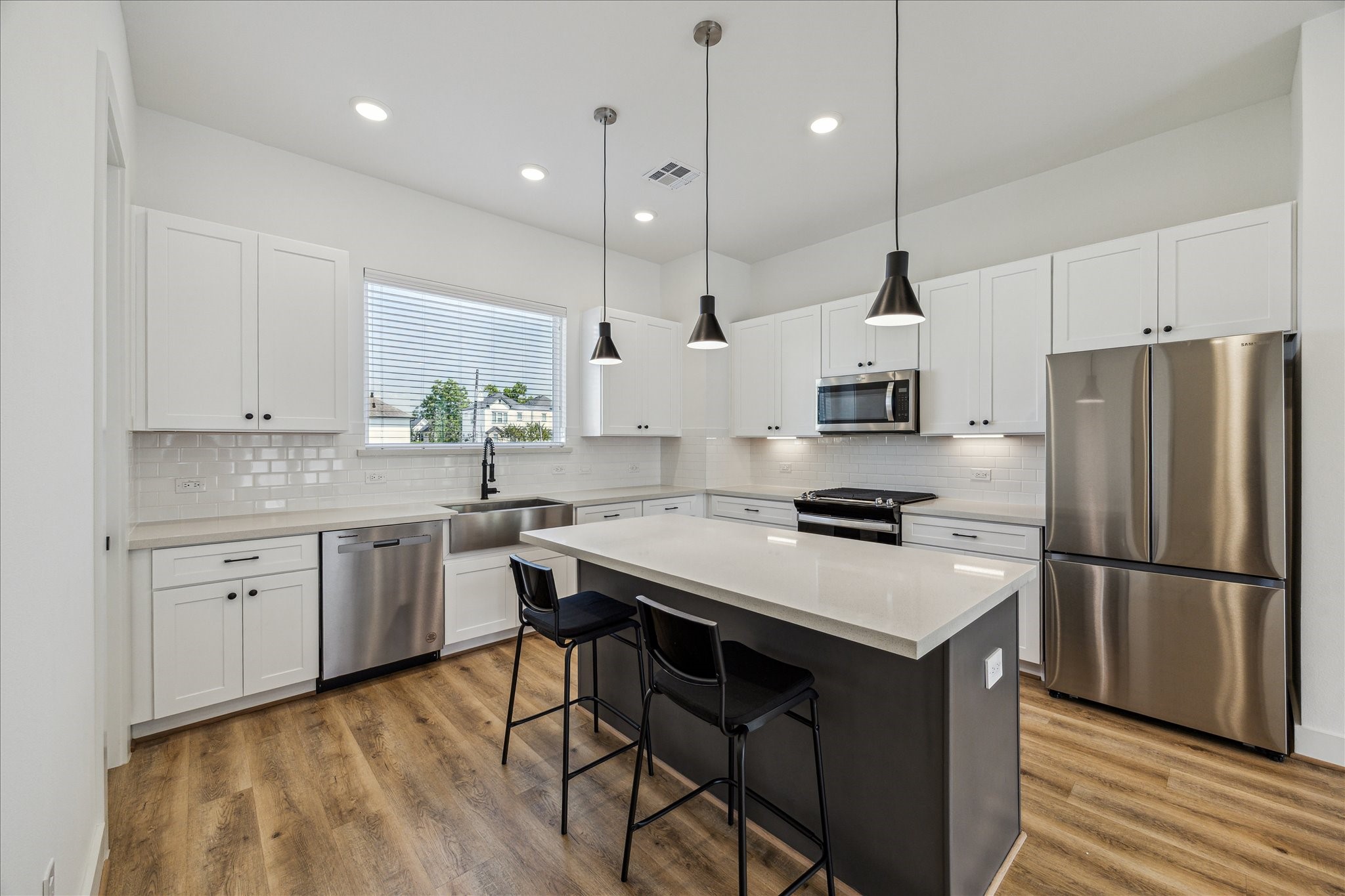 4854 Brinkman Street Houston, TX 77018 - Photo 9 of 30 The heart of the home—this kitchen offers an expansive island with seating, pendant lighting, farmhouse sink, and crisp white cabinetry for timeless appeal.
