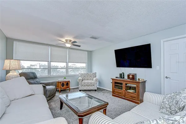 a living room with furniture a lamp on wall and a couch